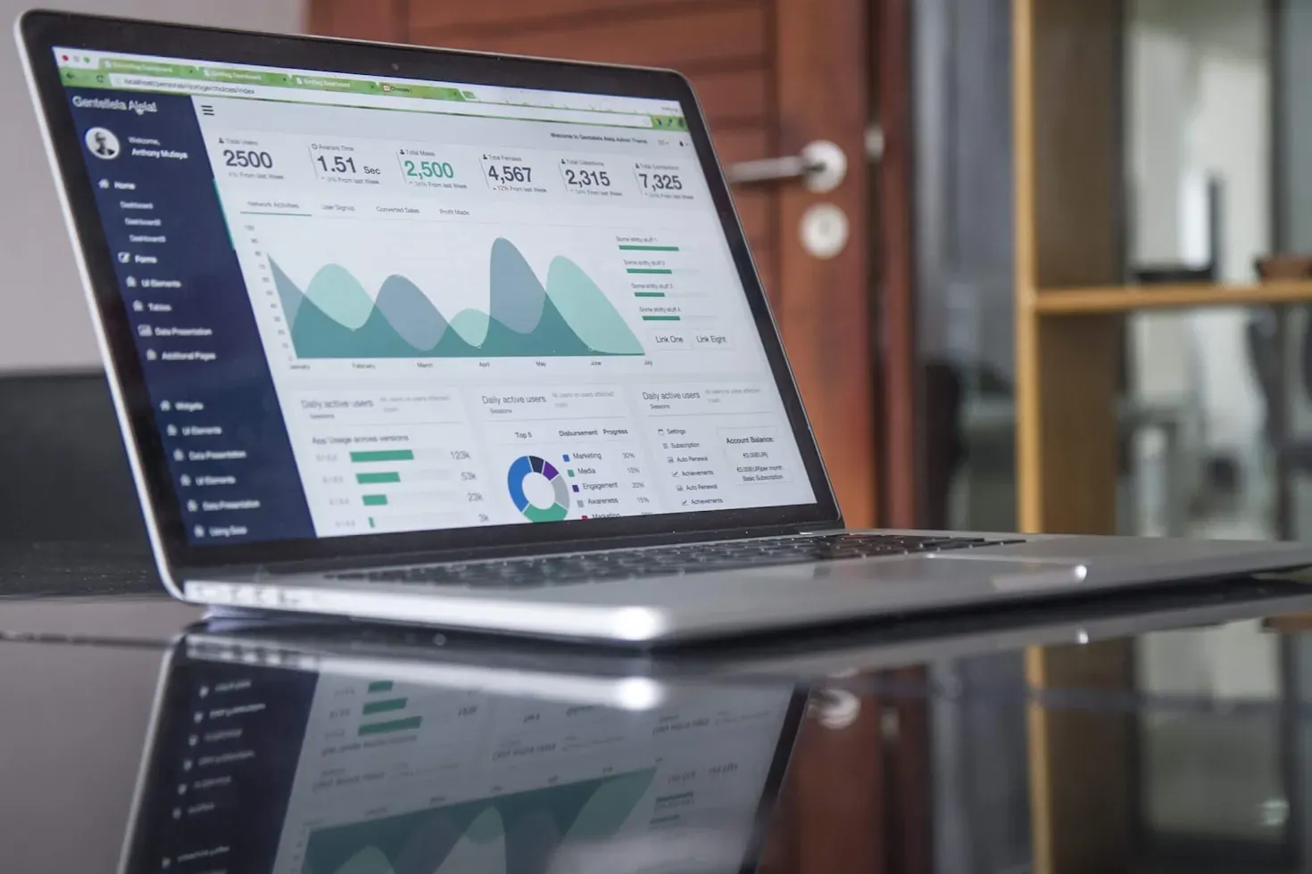 Someone working on a laptop with spreadsheet data